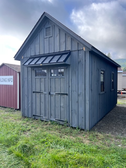 Grey board & batten shed with a hinged roof double doors and windows
