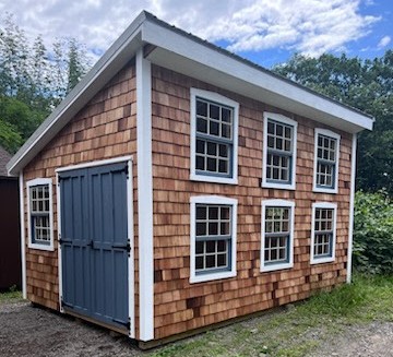 One slant shed with cedar shake siding double door and 8 windows