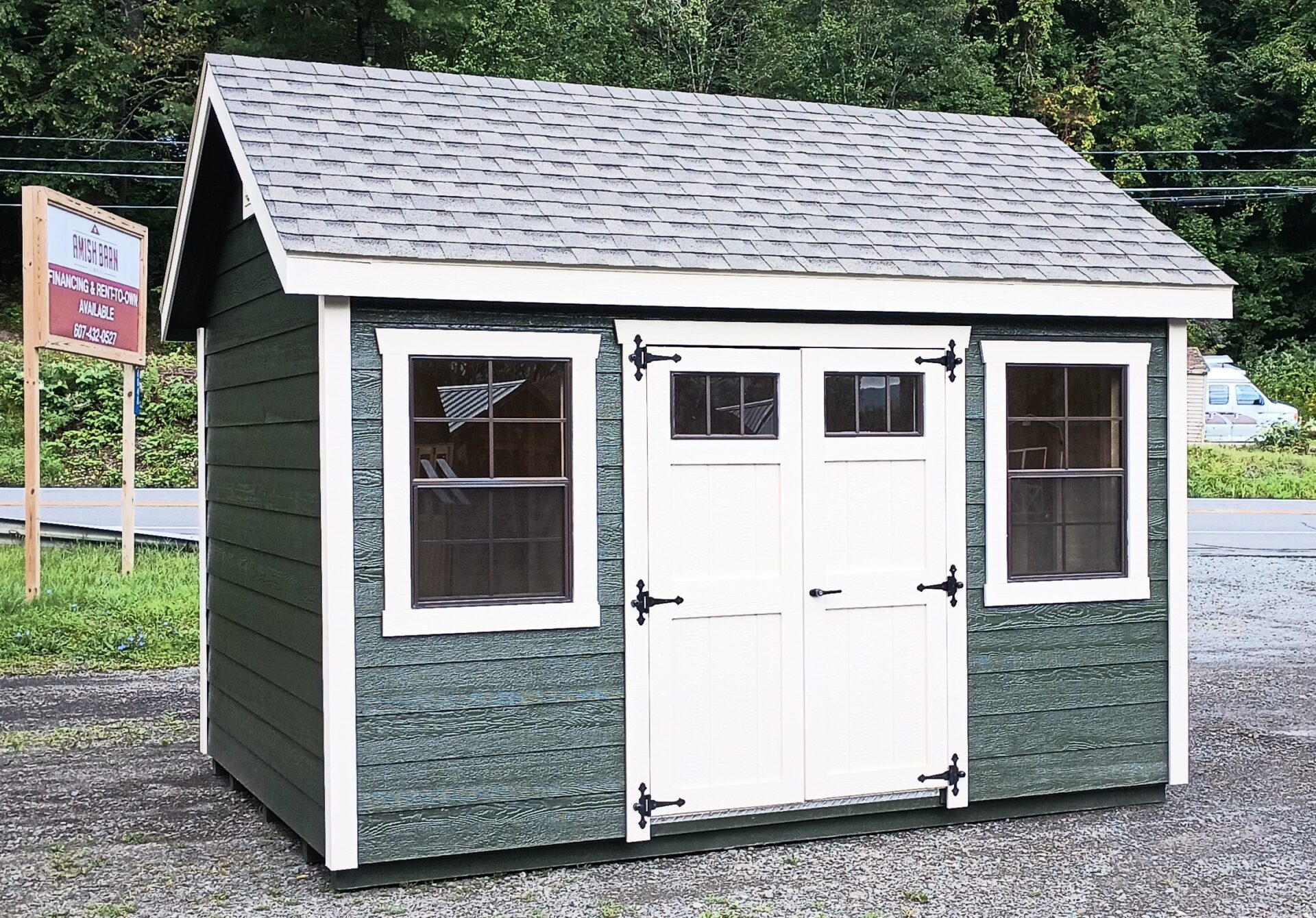Green shed with cream trim and doors, 2 windows, shingled roof