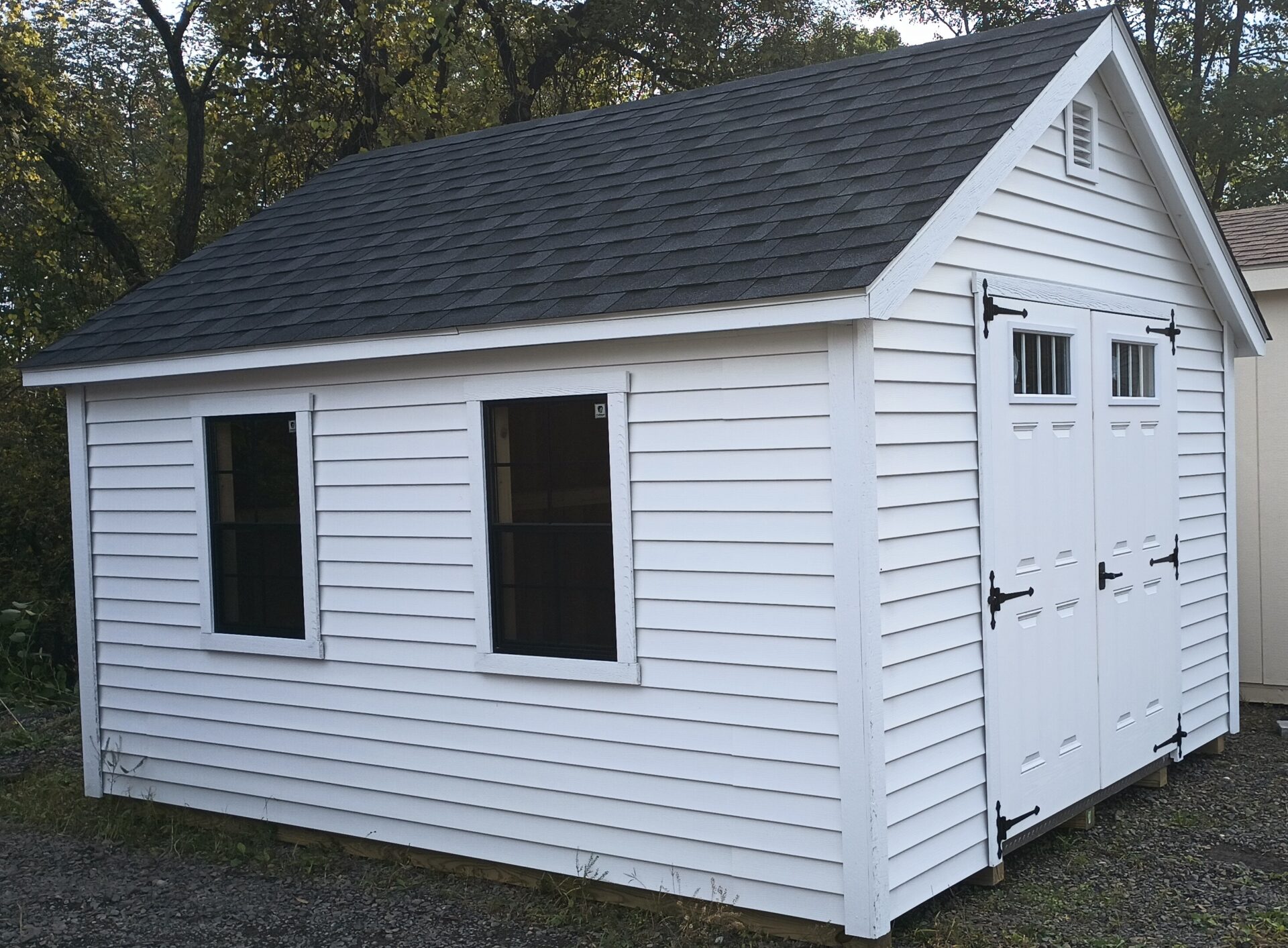 White shed with double doors and two windows