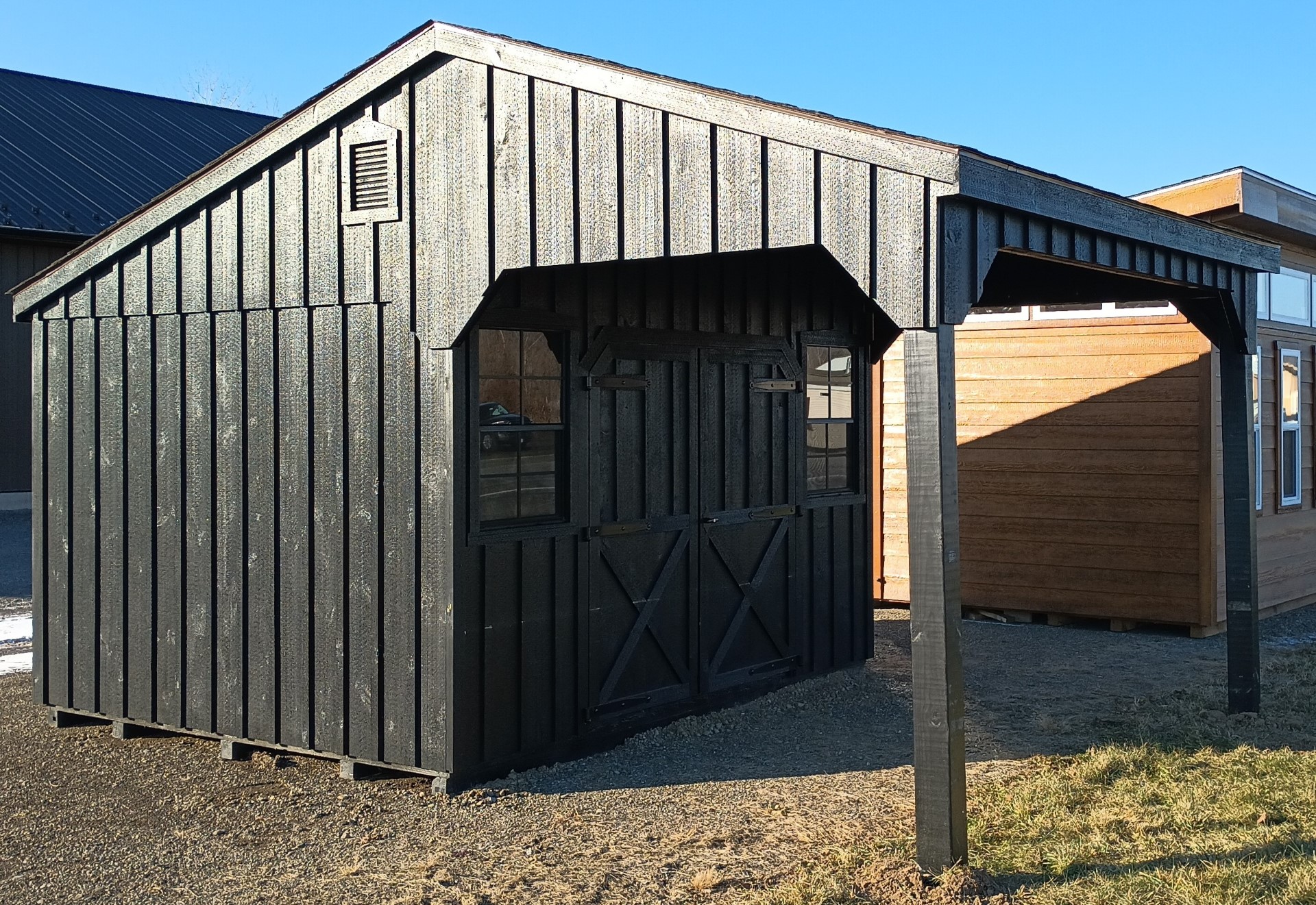Board & Batten black shed with overhang on the front