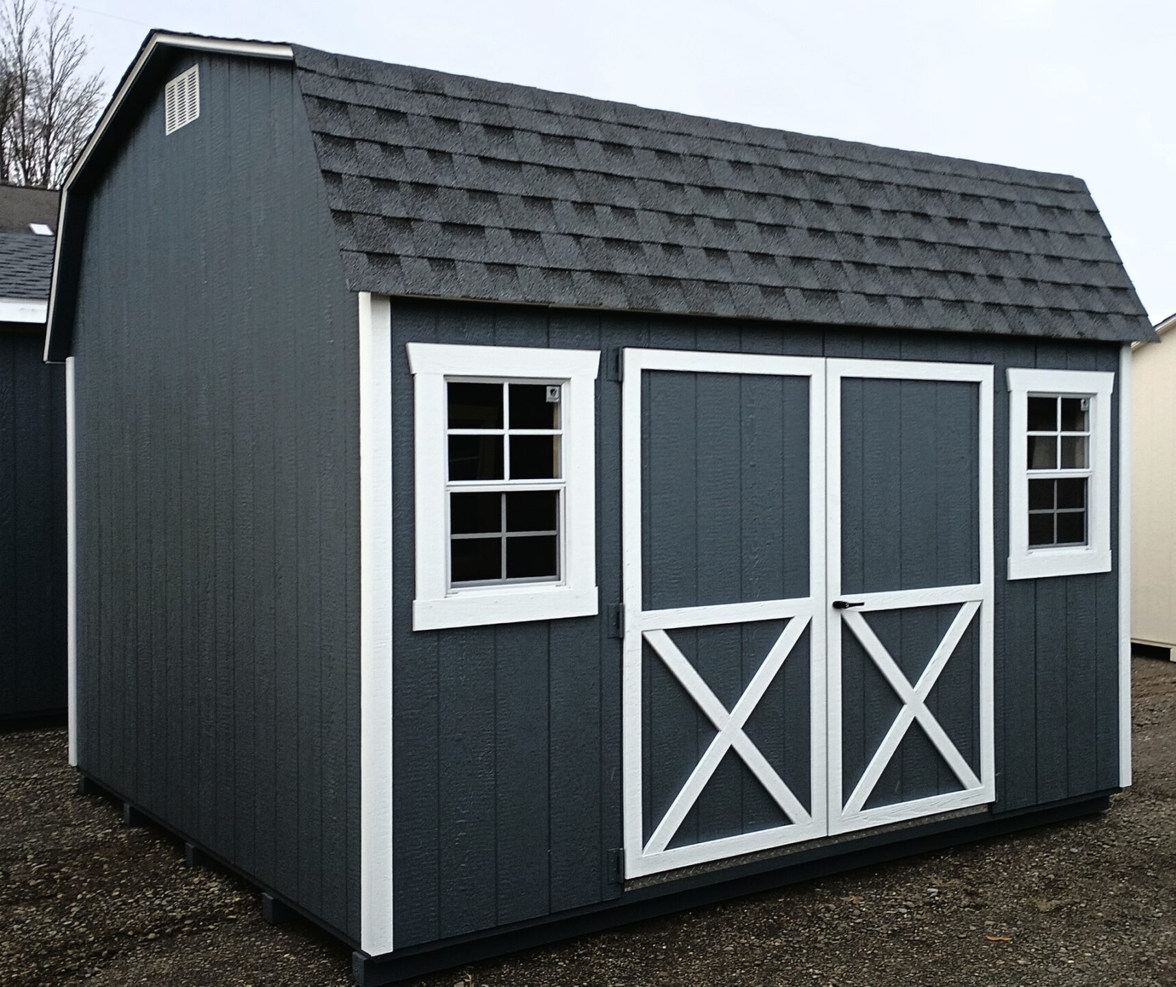 Dark gray barn with white trim, double doors and windows