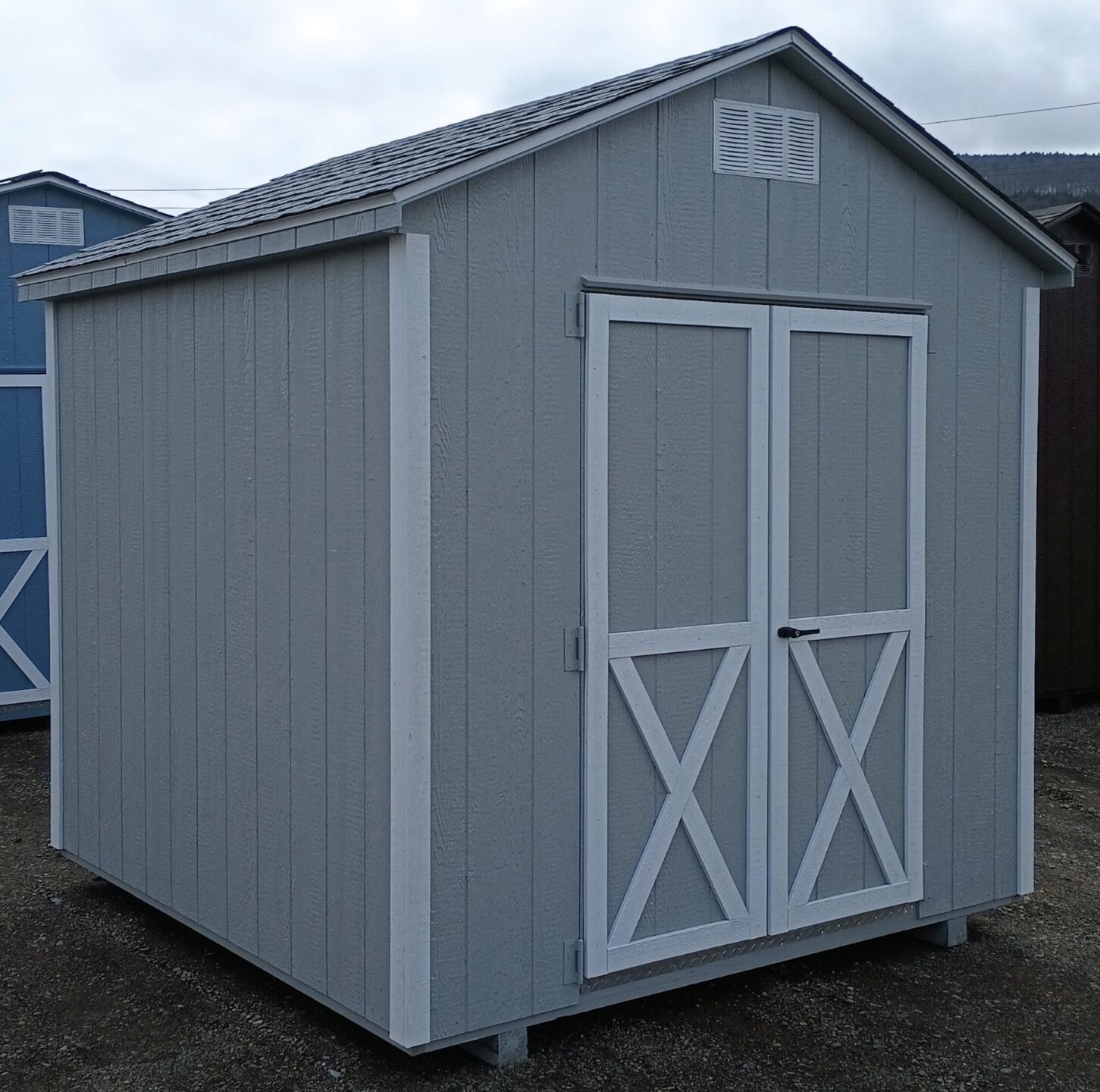 Small grey shed with white trim and double doors
