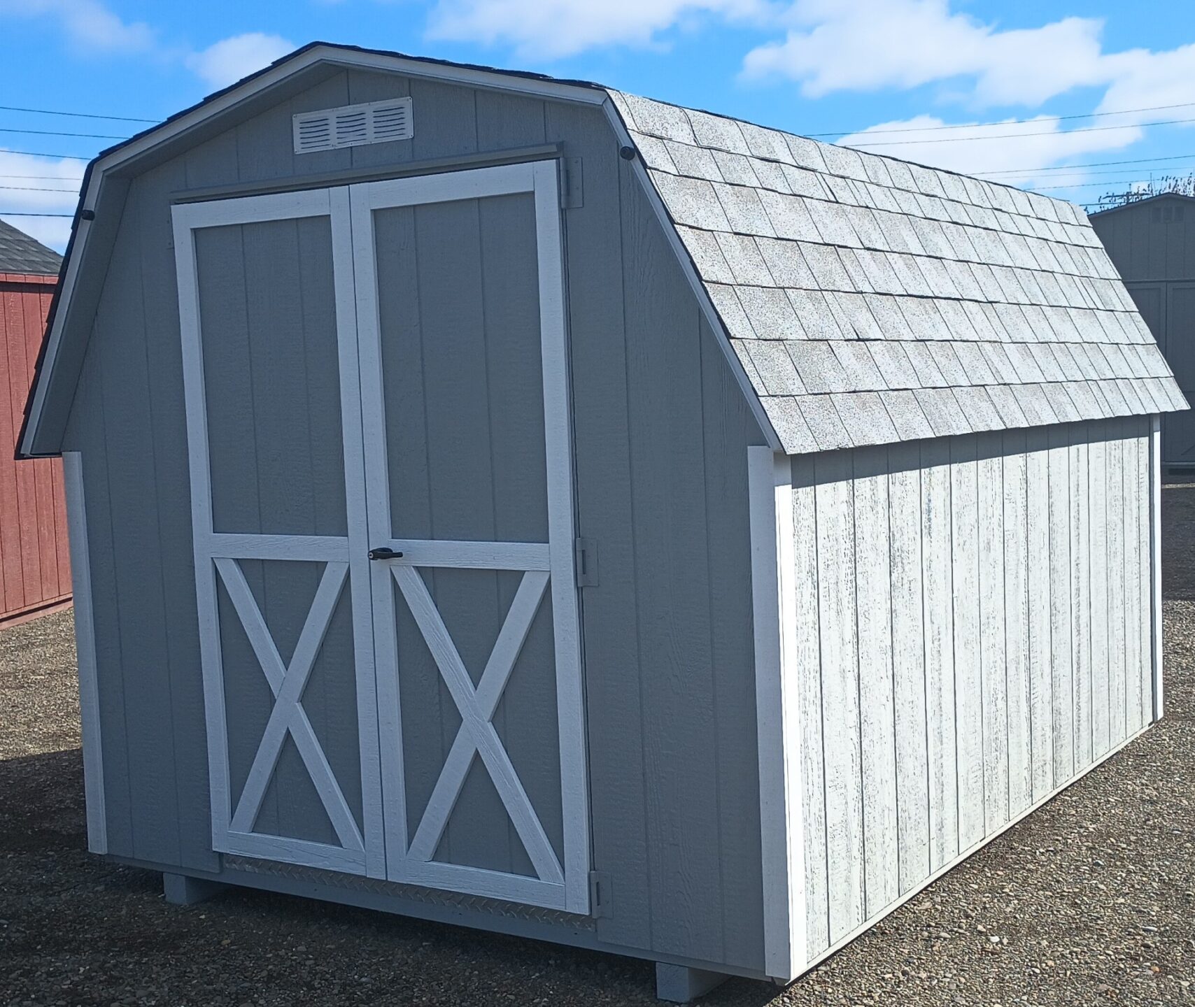Light gray wall barn with double doors and shingles