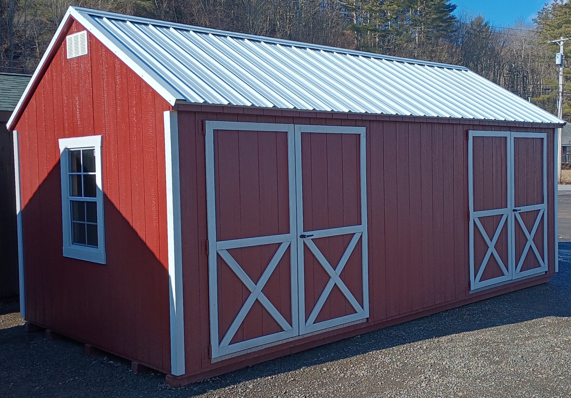 Red cape cod with white trim, metal roof, two sets of double doors on twenty foot side and a window on each end