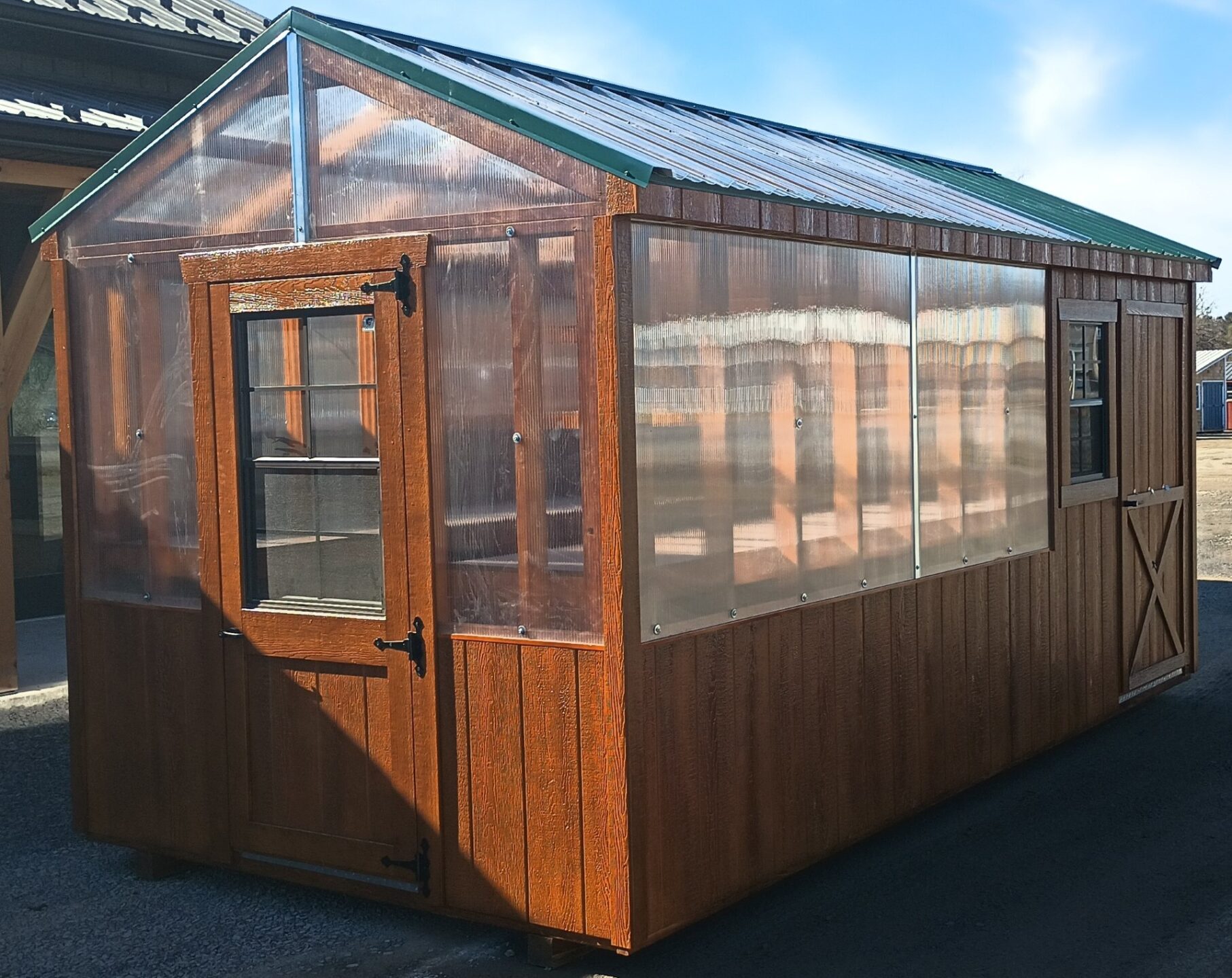 Stained greenhouse with entry door and clear panel half walls