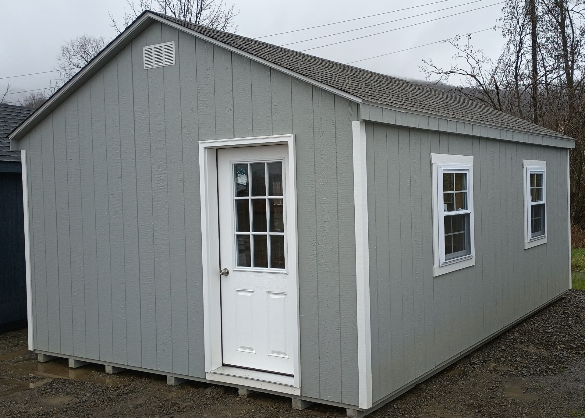Gray a frame shed with house door and 5 windows
