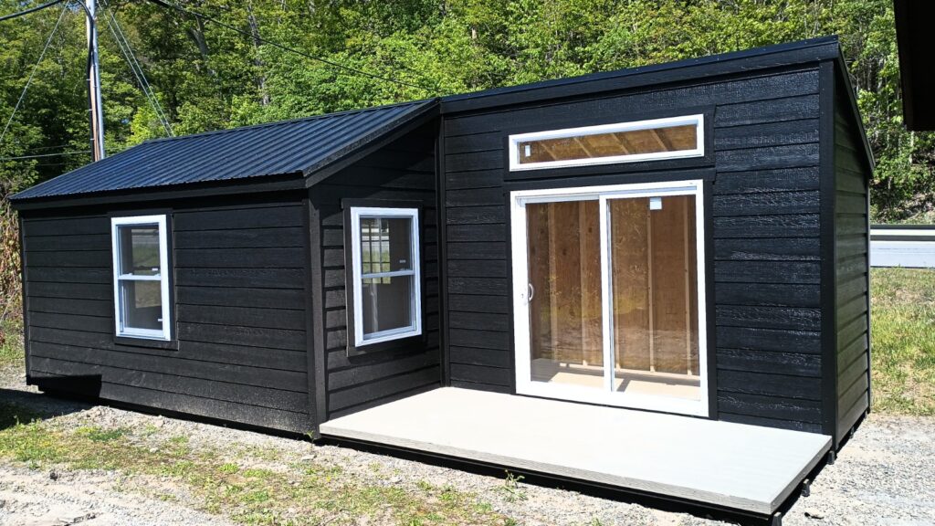 Custom, black, Amish-built shed with sliding glass doors and transom window for added light