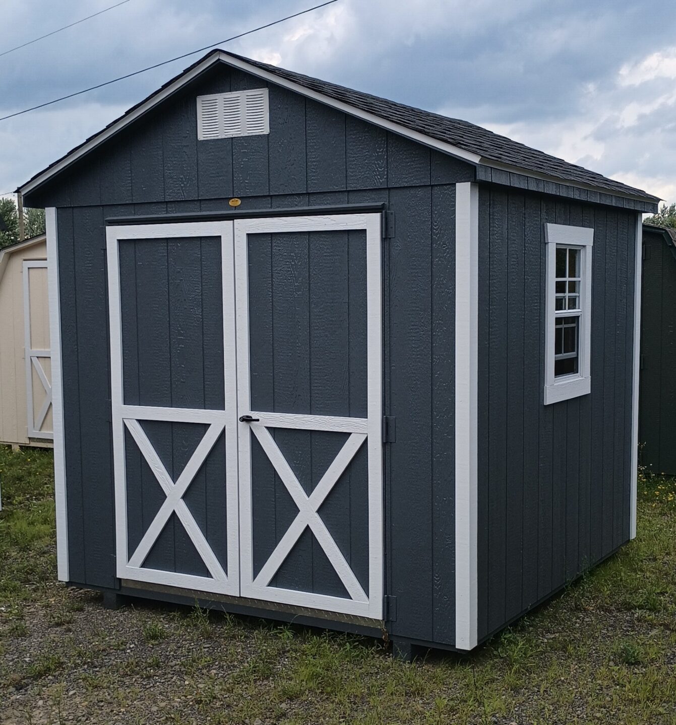 Dark gray shed with white trim and double doors