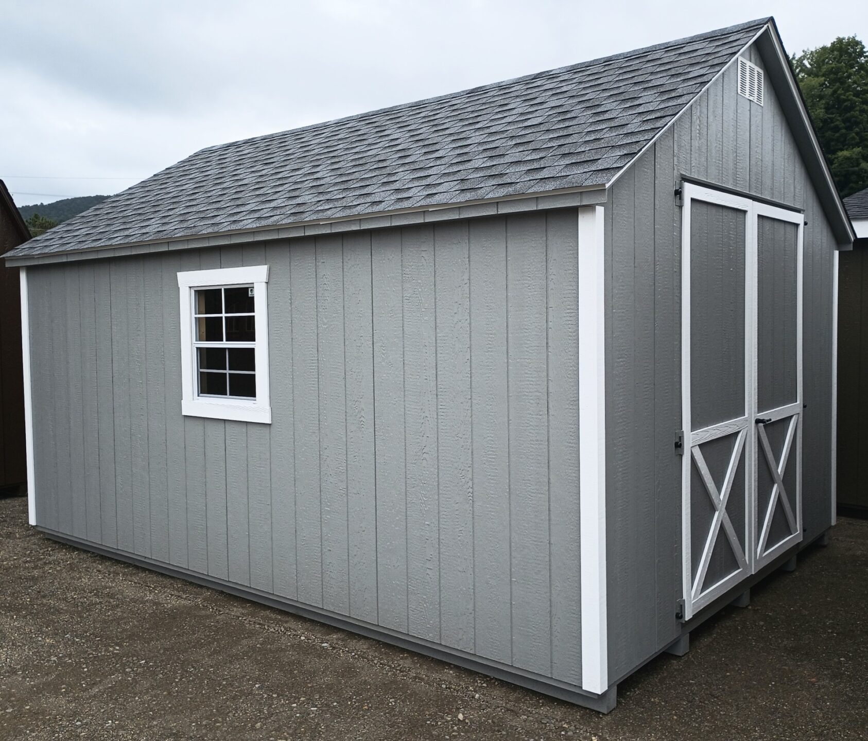 Peaked roof shed with double doors and 2 windows with a shingled roof