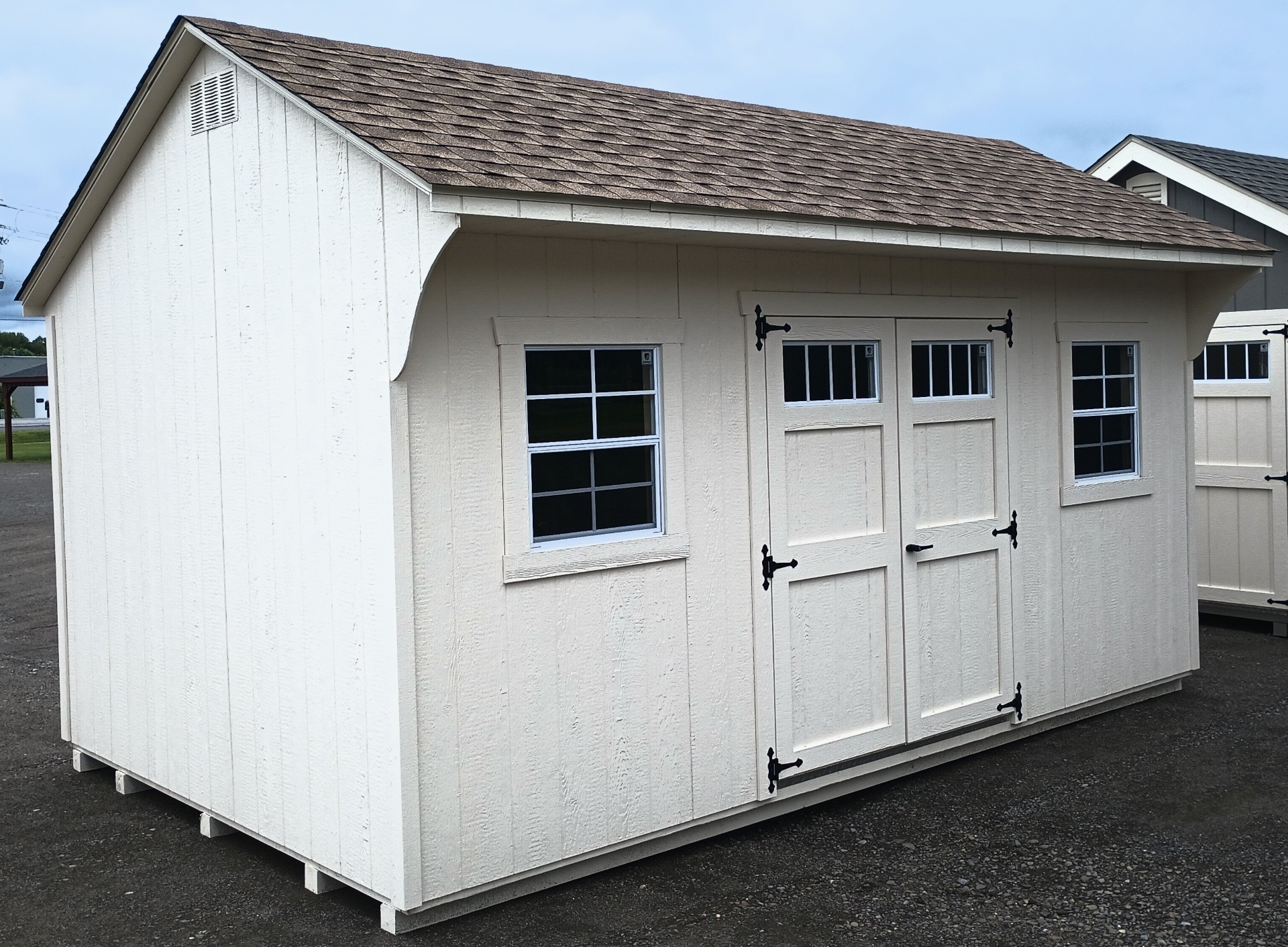 Quaker style shed with double doors with transom windows, 2 additional windows and shingled roof