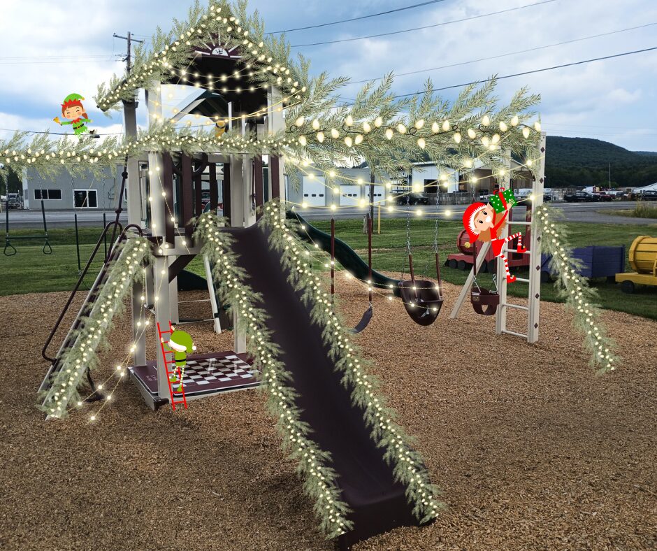 Swing set with slide and swings, as well as a small rock wall and sandbox