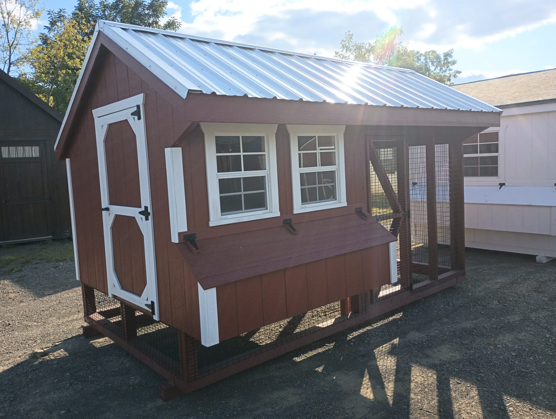 Red chicken coop with coop area and run area, 2 windows and access door on side