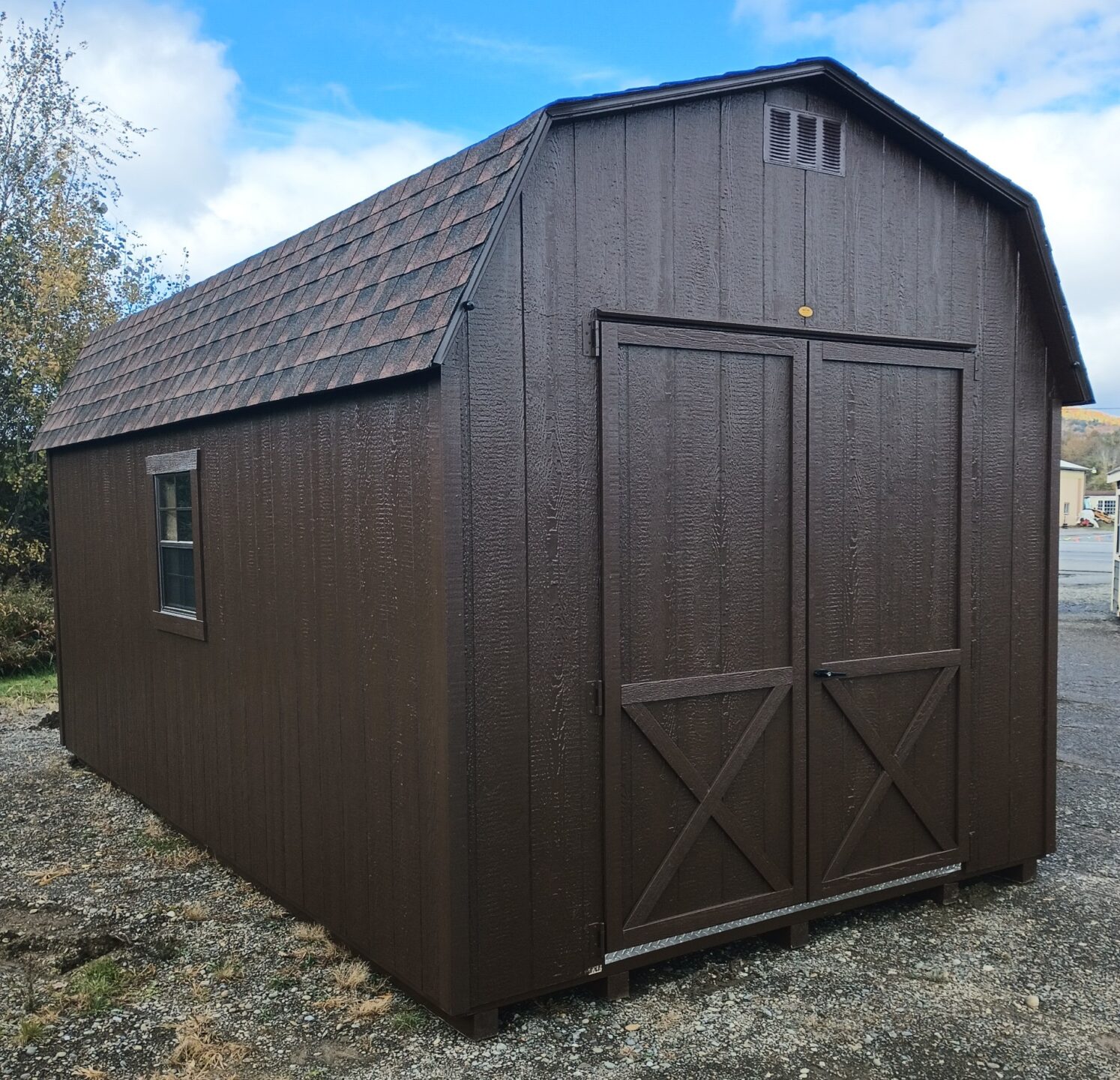 Large brown shed with oversized doors and two windows