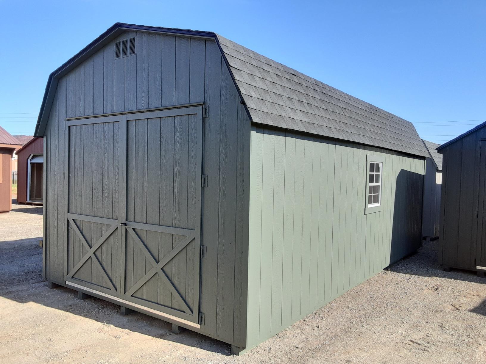 Large avocado color shed with oversized double doors on the end, shingled roof and a window on either side