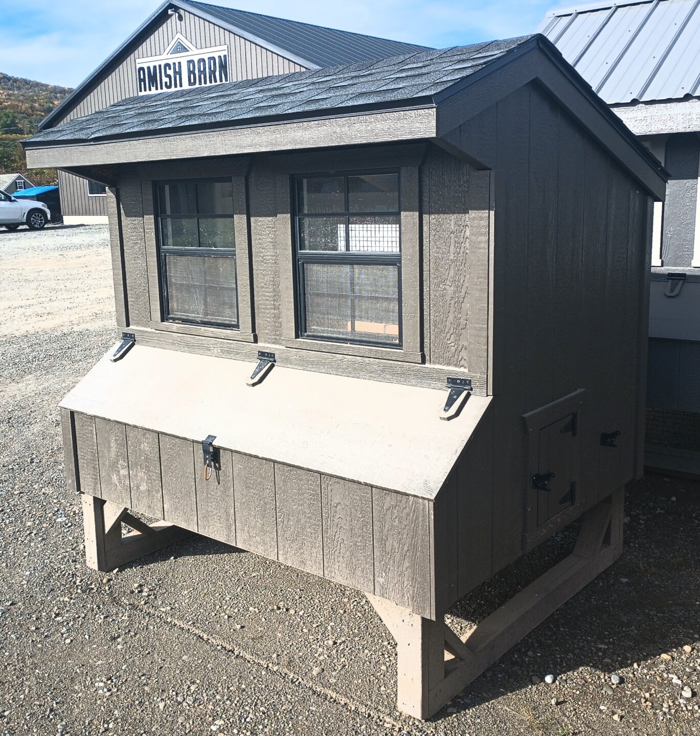 Small chicken coop with nesting boxes on the outside and two windows with side access door