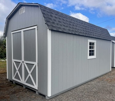 Gray shed with large double doors, shingled roof and two windows