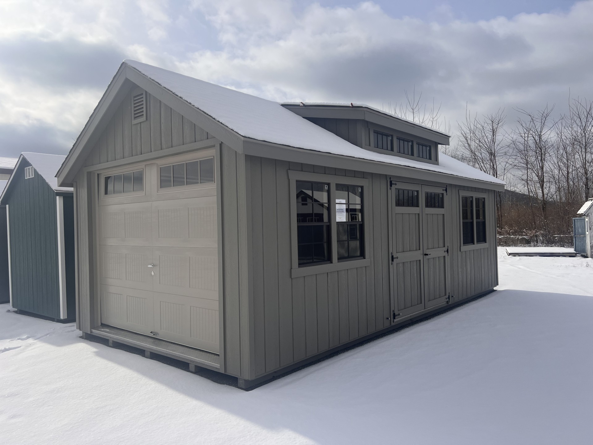 Shed with Garage door at end, double doors and windows on long side and transom dormer above