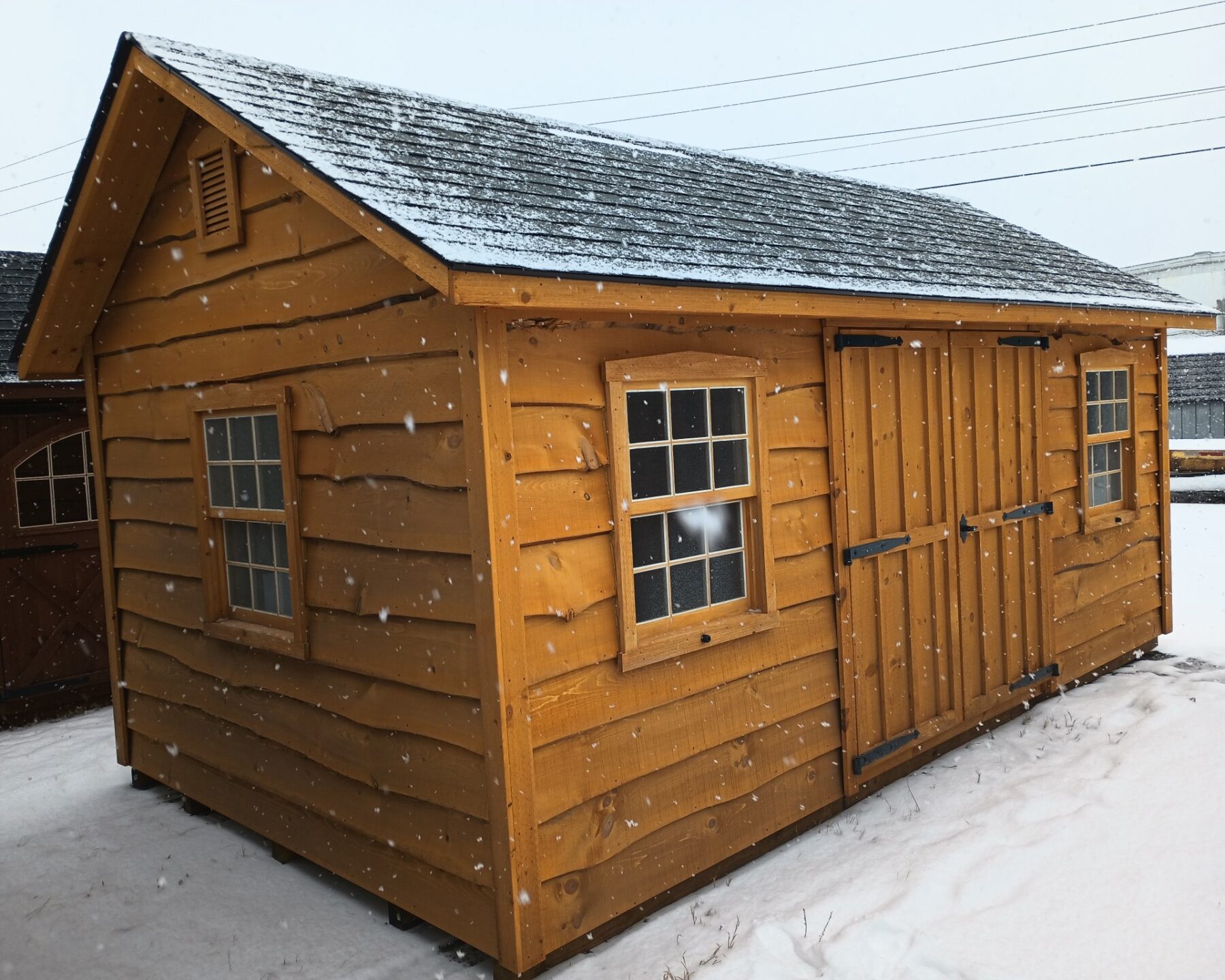 Heritage sided shed with double doors and two windows on either side of the doors as well as on each end