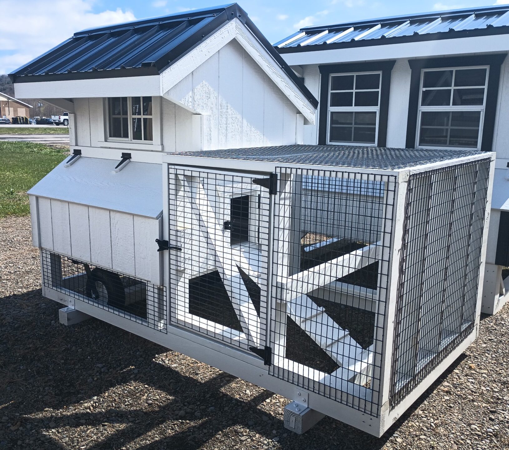 Small white coop with tractor wheels and small run area