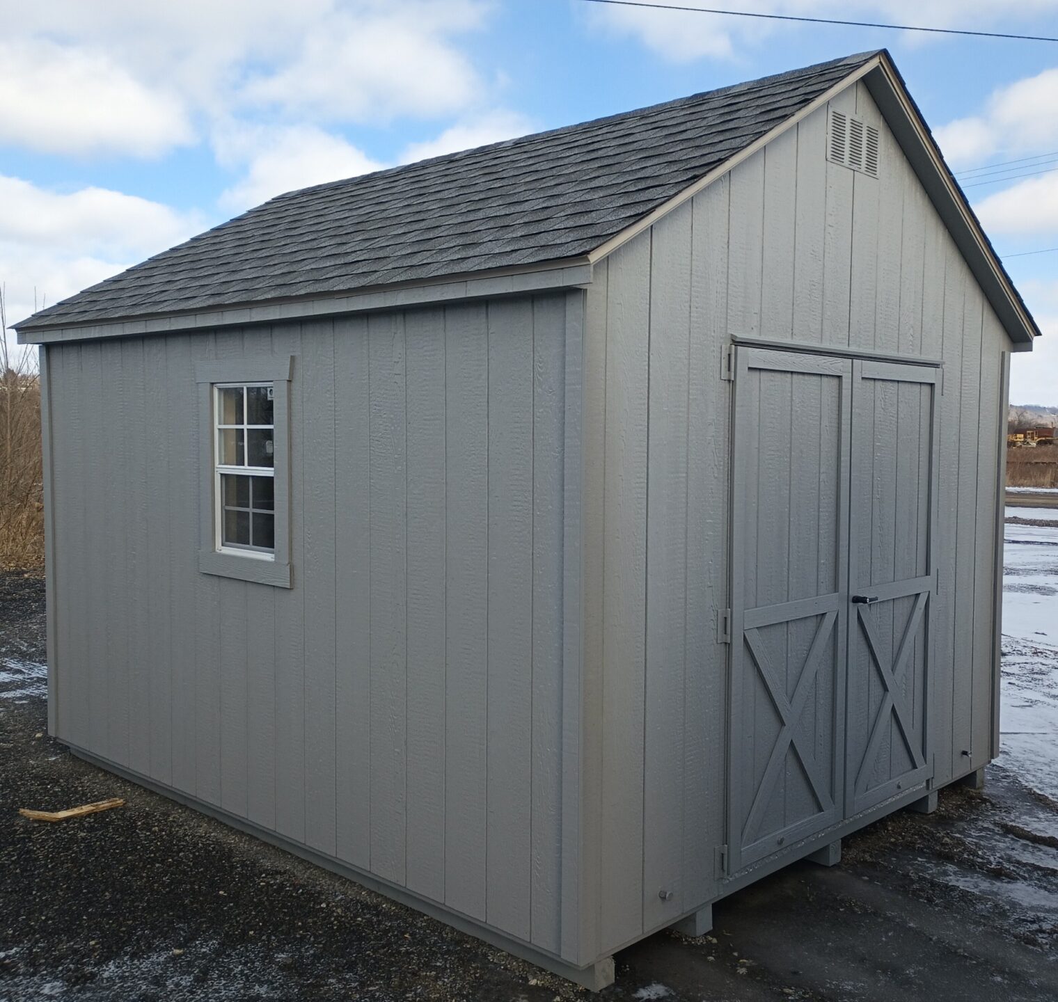 Grey shed with double doors, two windows and shingled roof