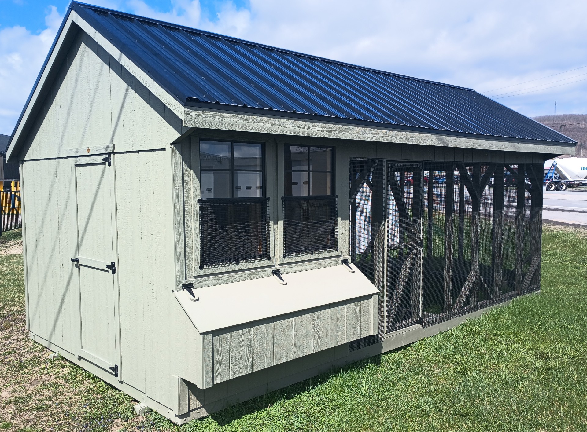 Green chicken coop with run area, nesting boxes and two windows
