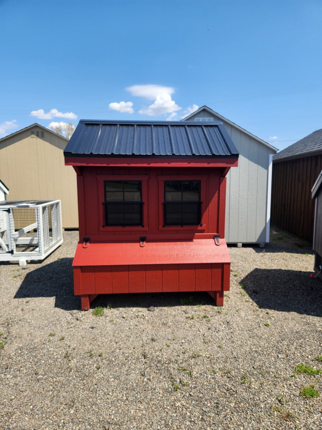 Small red chicken coop with access door, nesting boxes and two windows