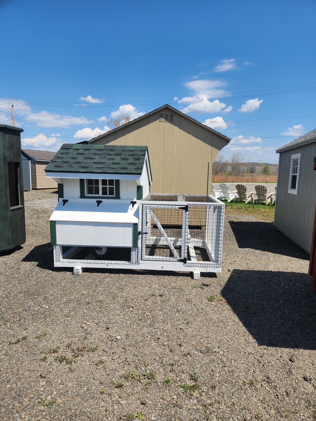 Small white coop with run area and green trim, small window and access door