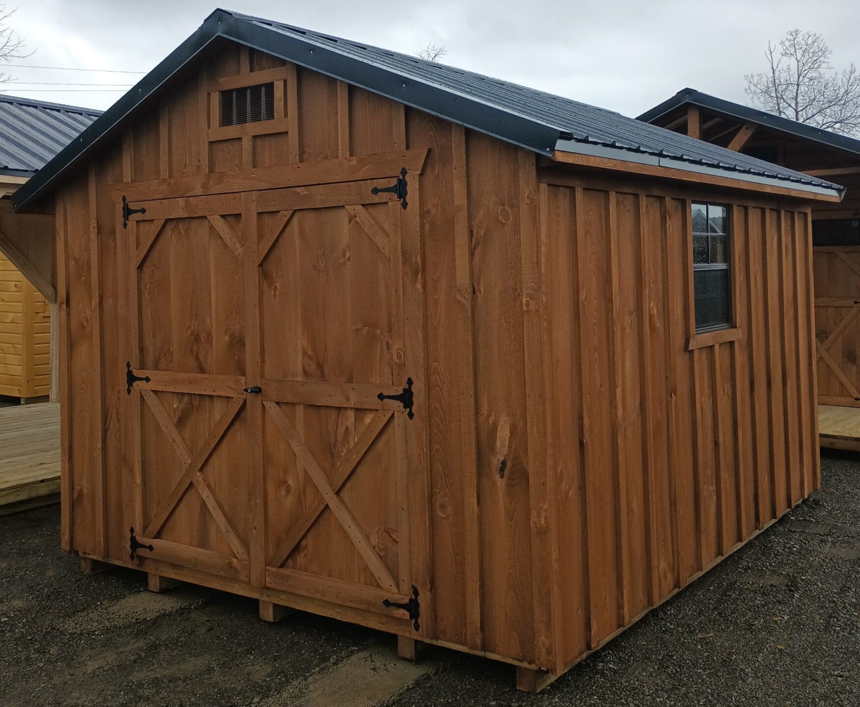 Board and batten shed with double doors, gable vents, metal roof and windows on either side