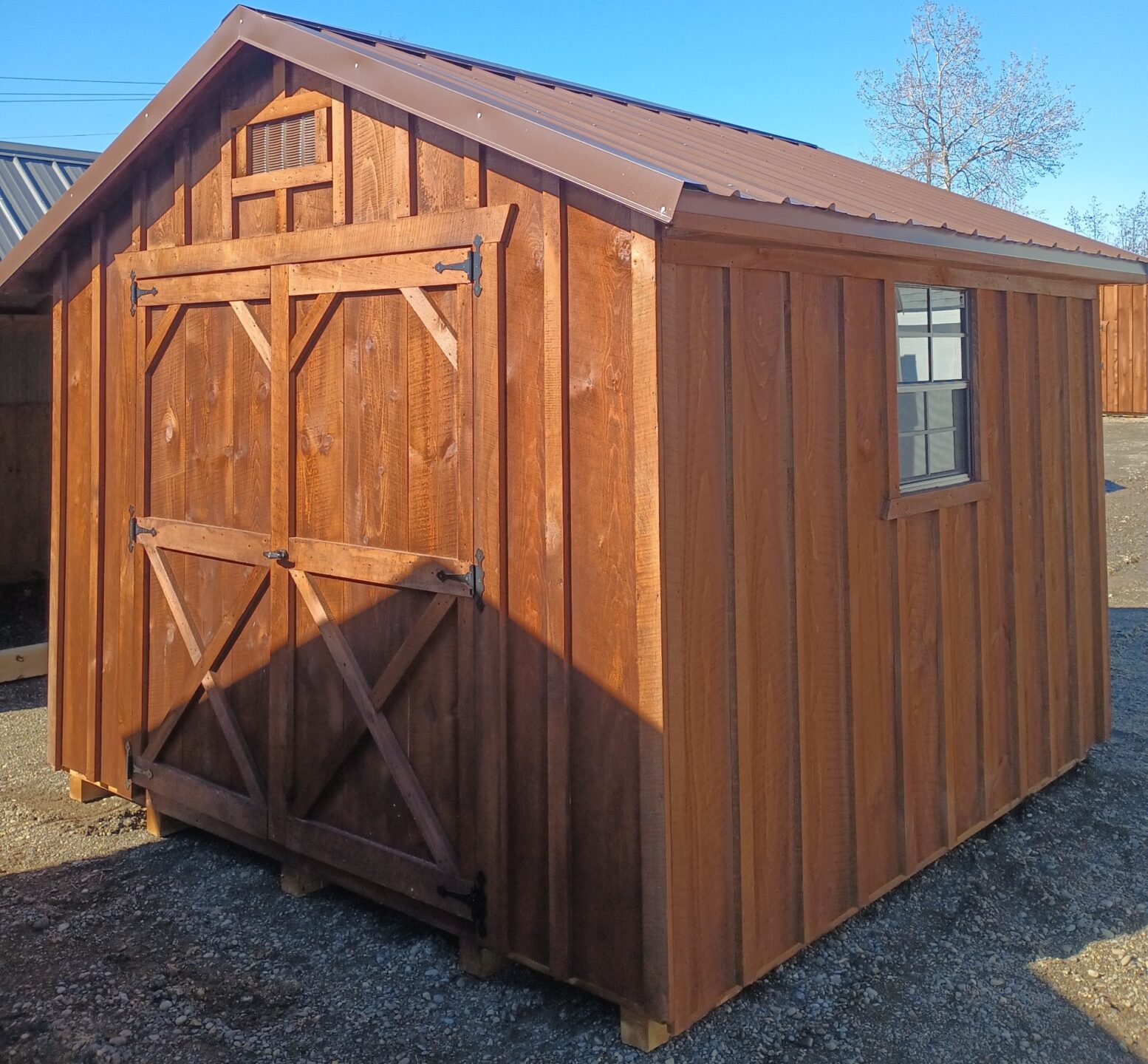 Small board and batten shed with metal roof, double doors and two windows