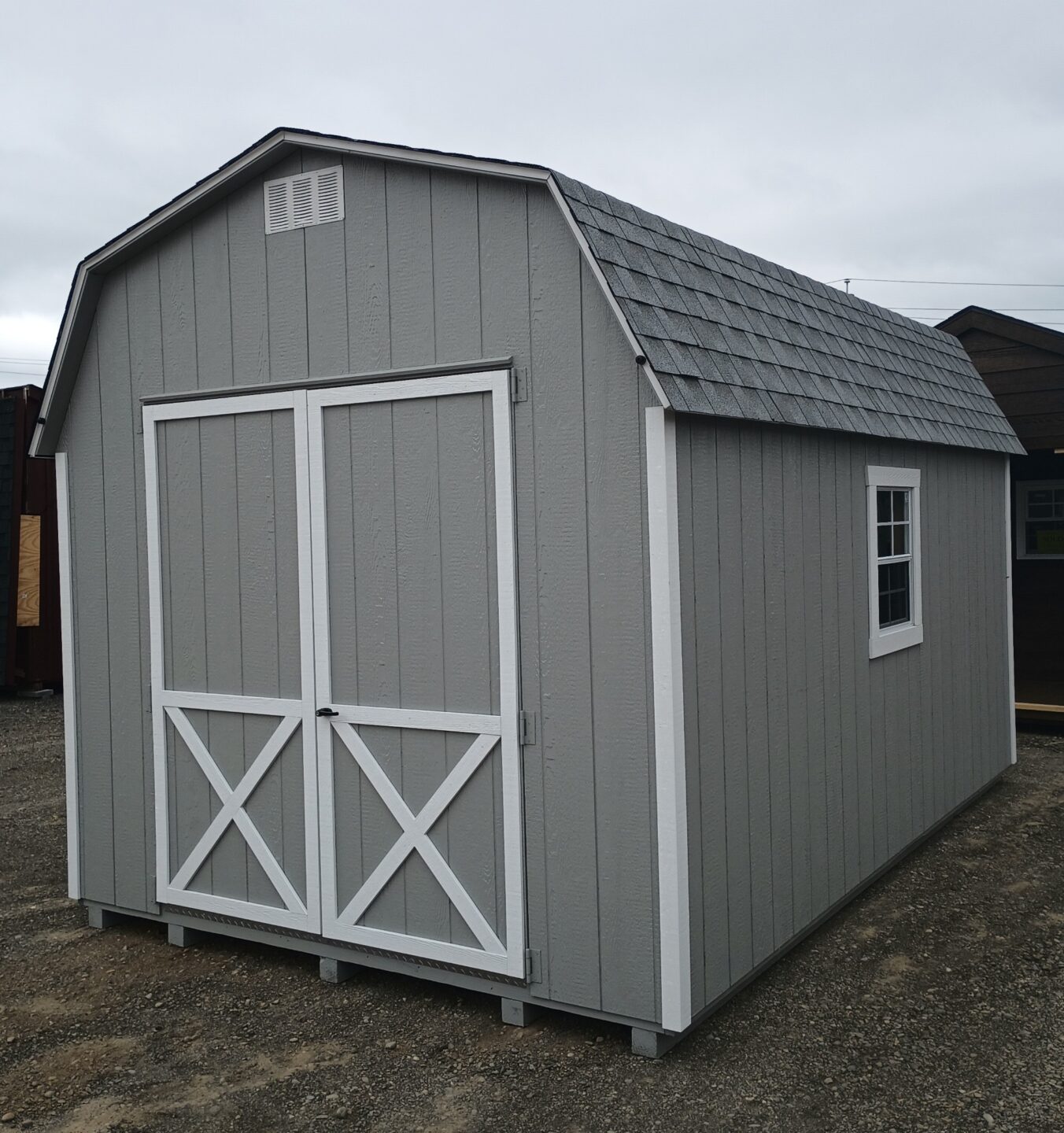 Barn style shed with oversized double doors, two windows and shingles