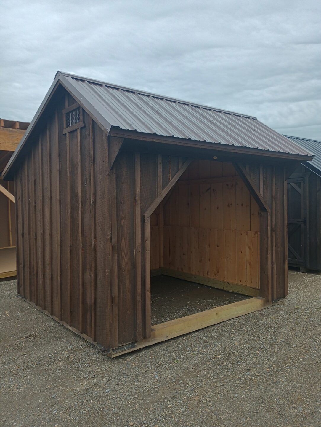 Dark color run in shed with brown roof and front opening