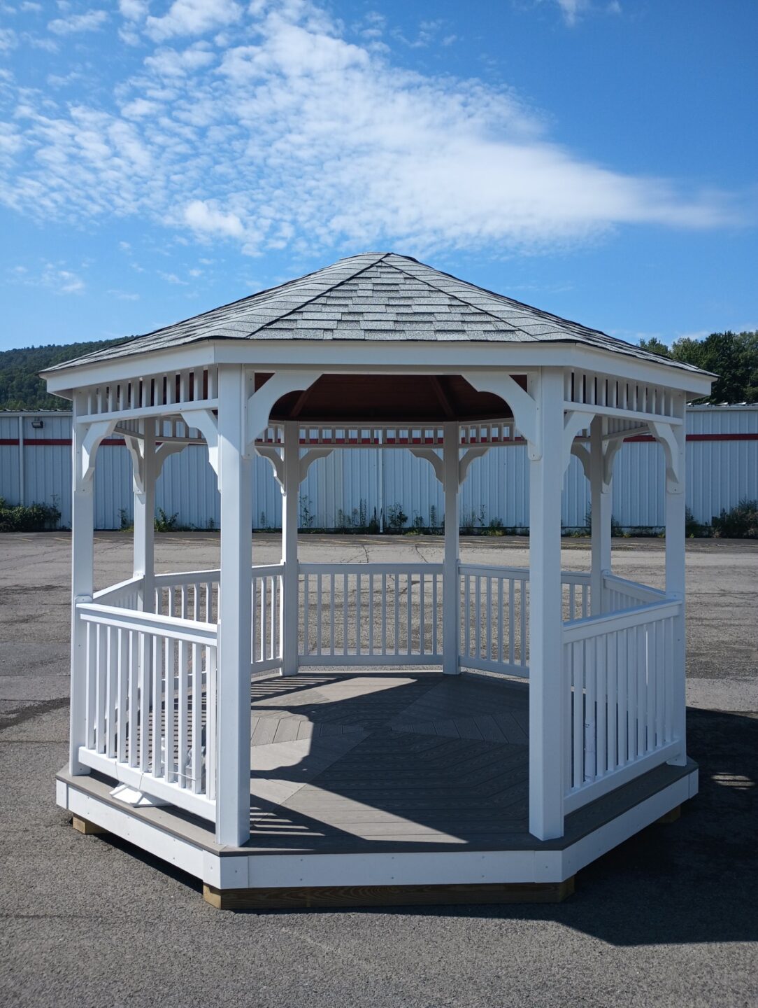White vinyl gazebo with opening, shingled roof and spindled handrails