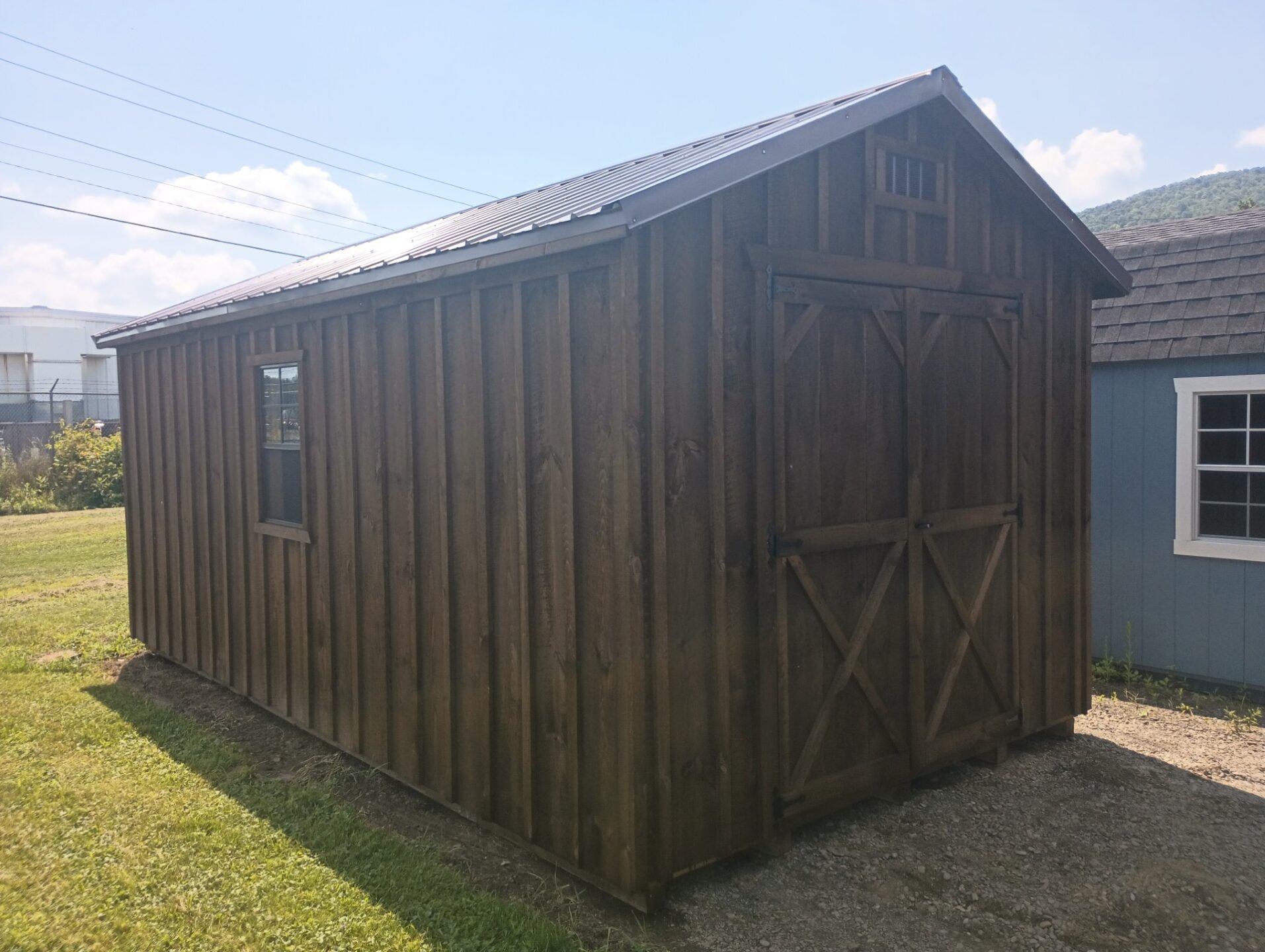 Board and batten shed with double doors, metal roof and two windows