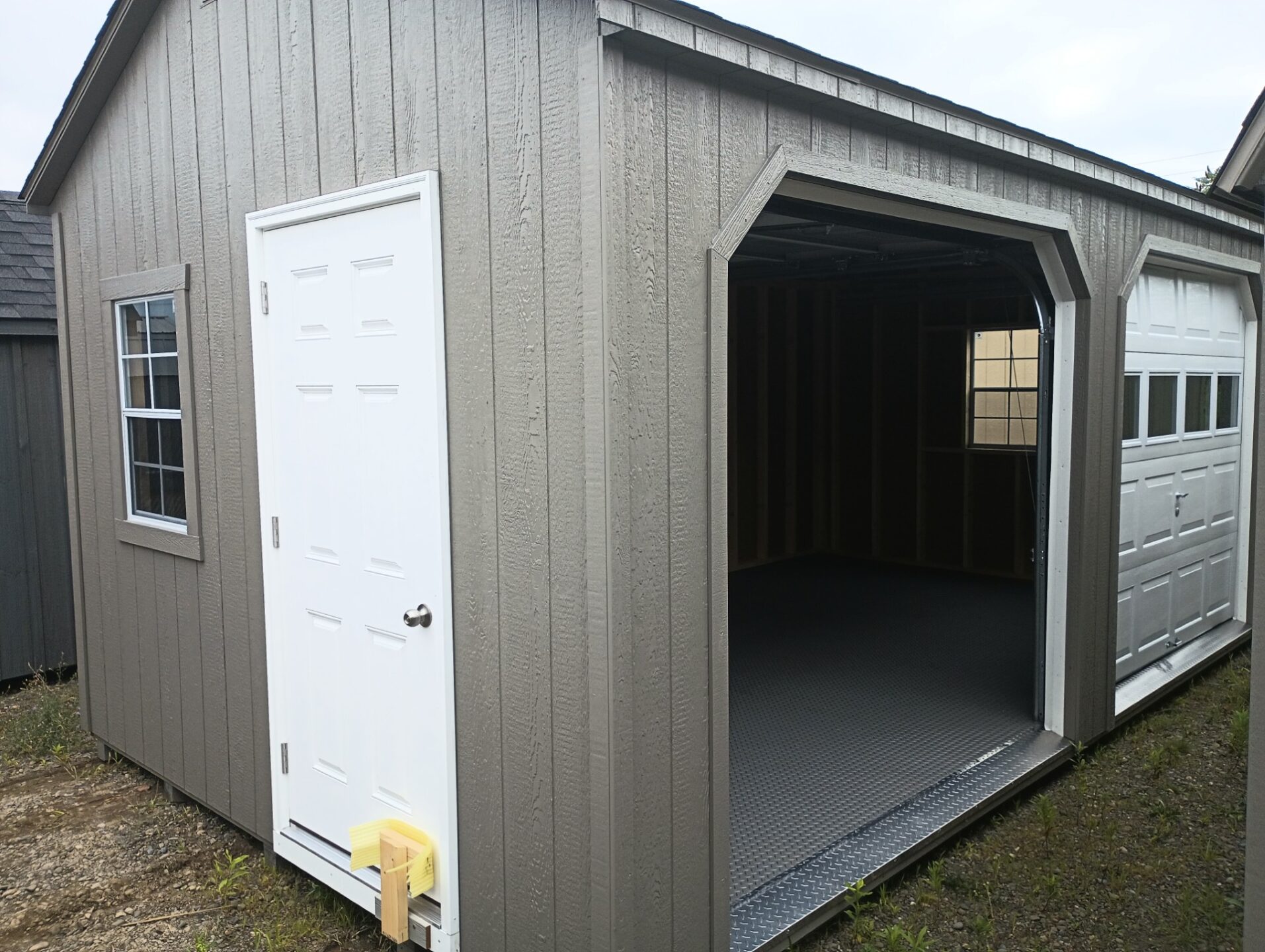 Shed with two garage doors on long side, with side door and windows
