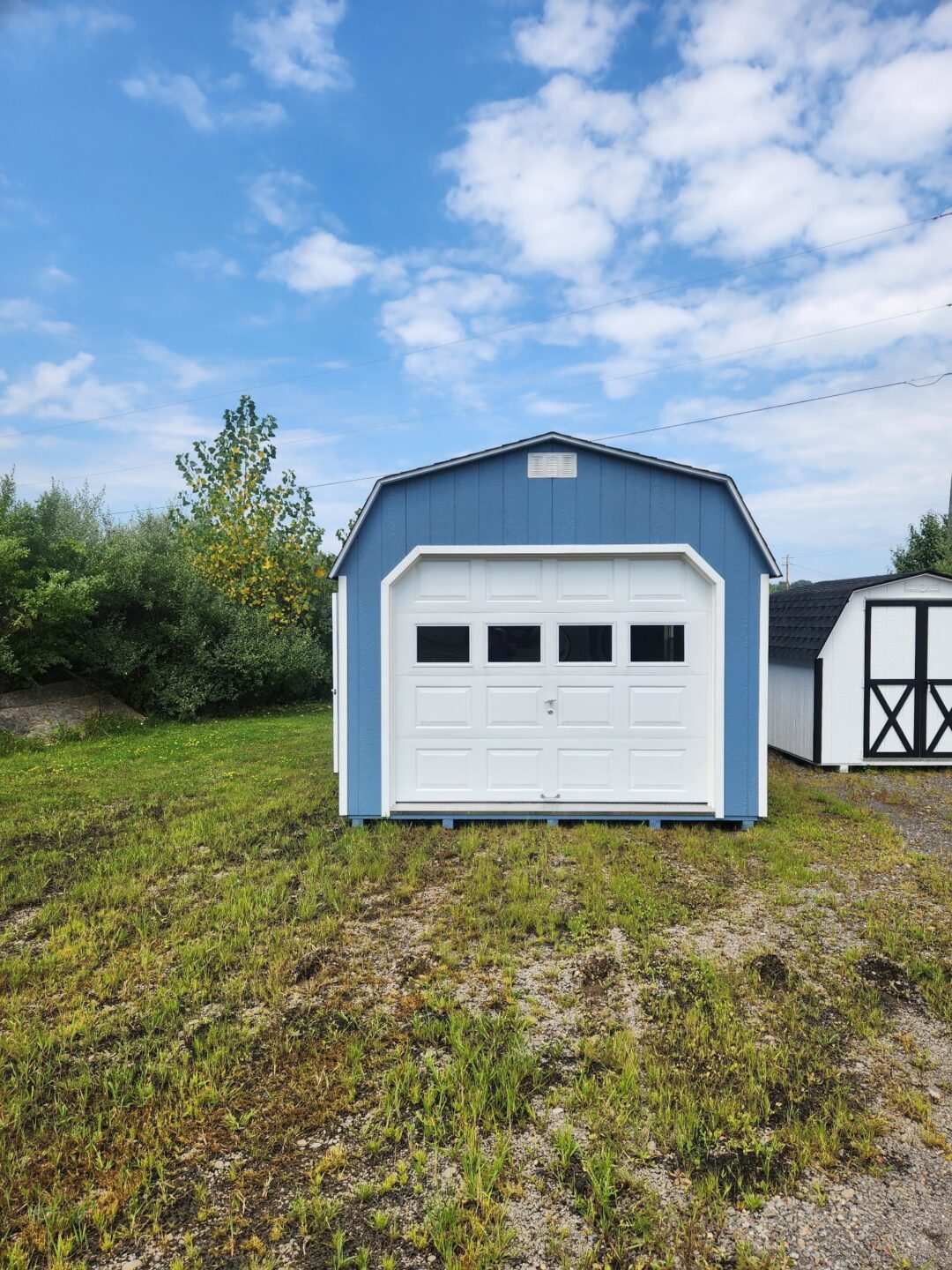 Barn style shed with overhead garage door with windows and gable vents