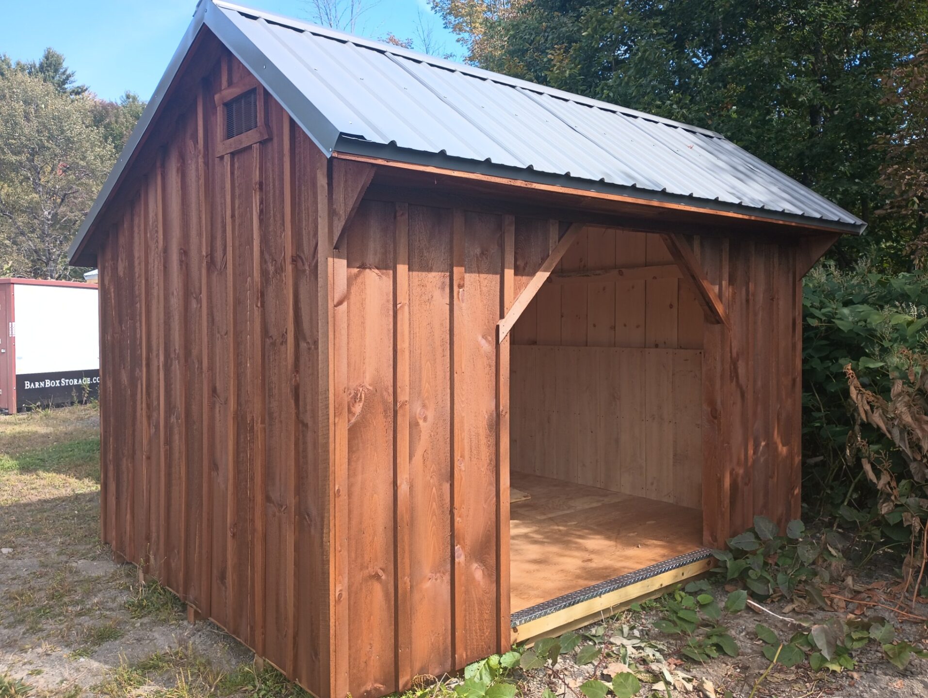 Small board and batten structure with metal roof, front opening and pressure treated flooring