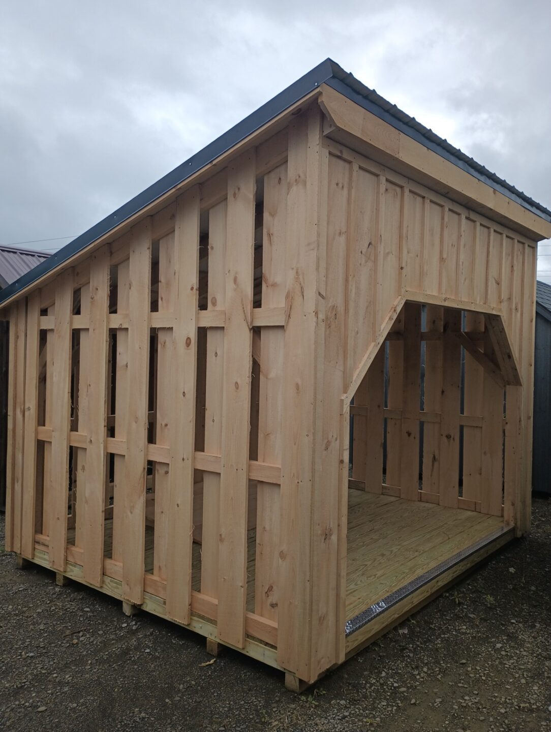 Slat sided one slant shed with front opening and flooring with diamond plate threshold