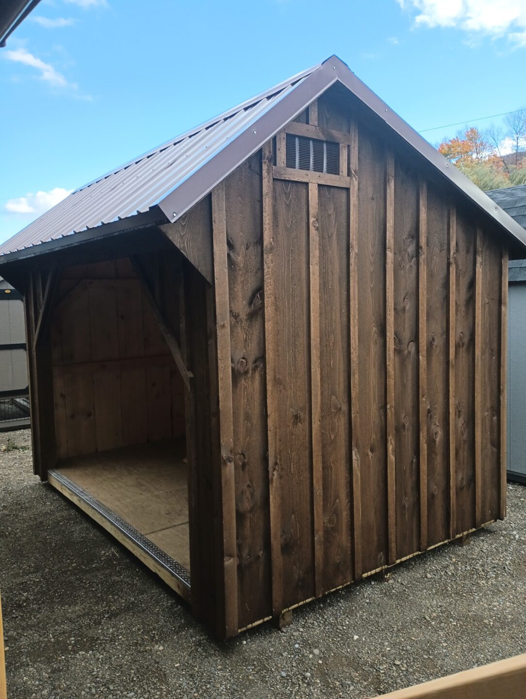 Rustic firewood shed with metal roof and floor