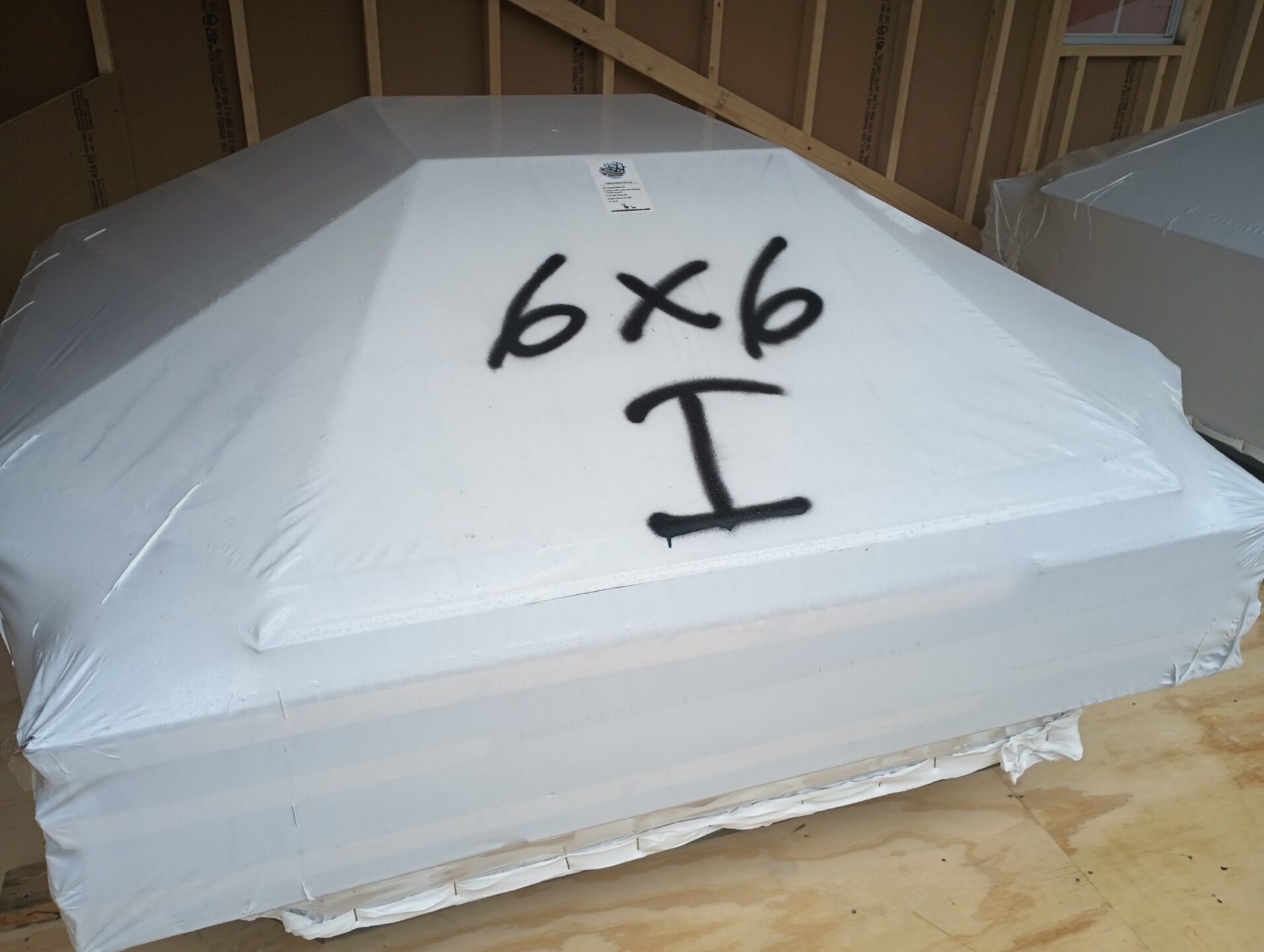 Shrink wrapped image of a hunting blind with 6x6 I for insulation spraypainted on it