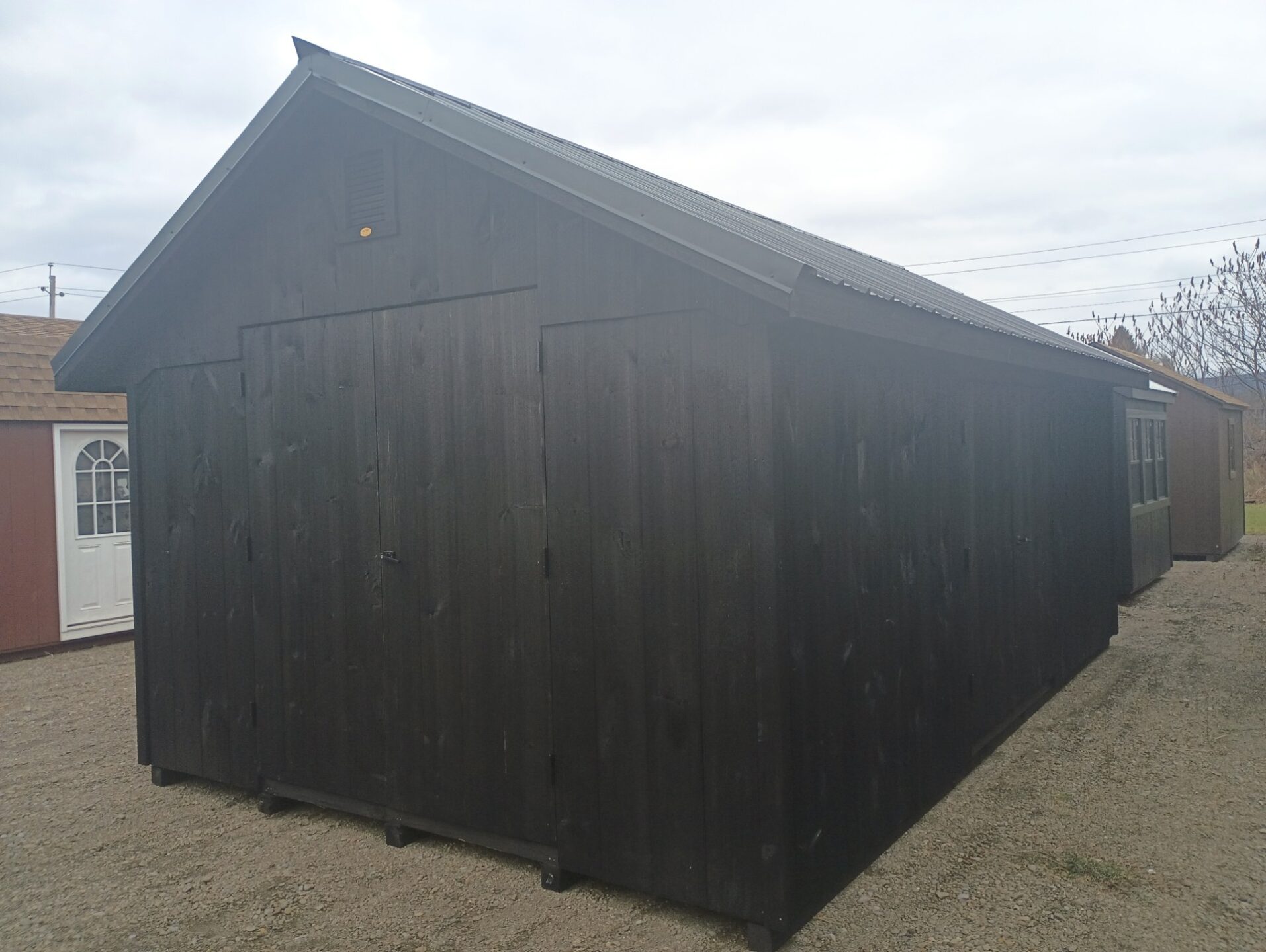 Black shed with vertical siding and two sets of doors